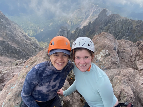 students wearing helmets sitting on top of a mountain
