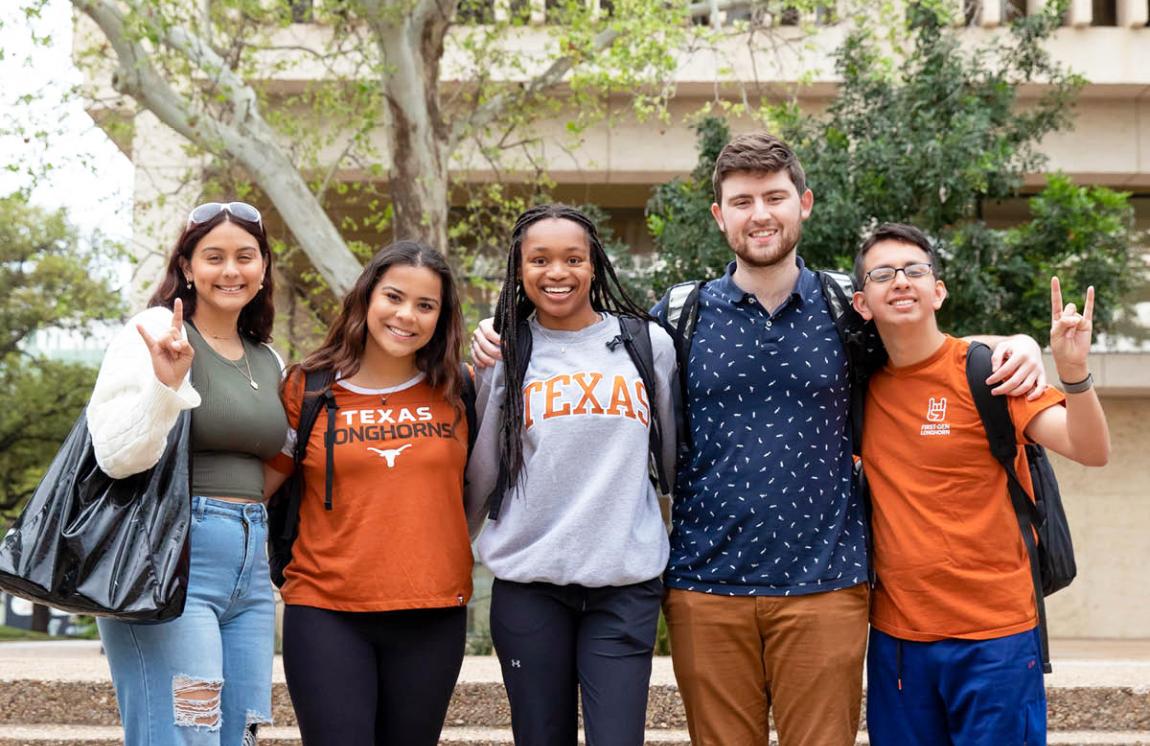 group of students posing and holding hook 'em hand sign