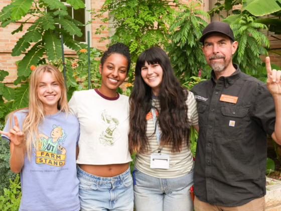 Four people posing for a photo in a garden.