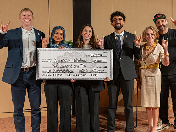 A group of people pose with a large check.