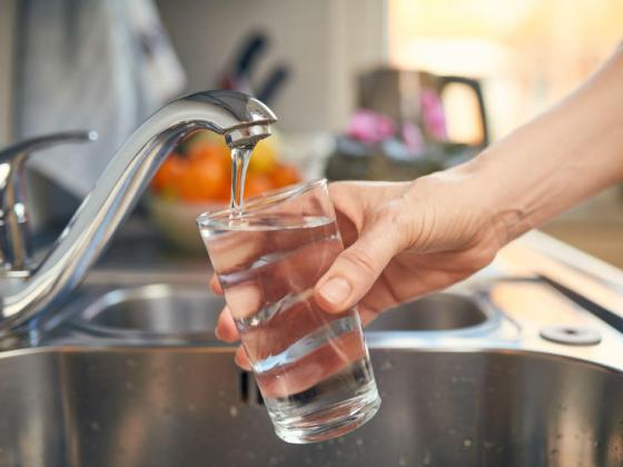 Person filling a cup with tap water