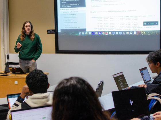 A professor giving a lecture in a college classroom.