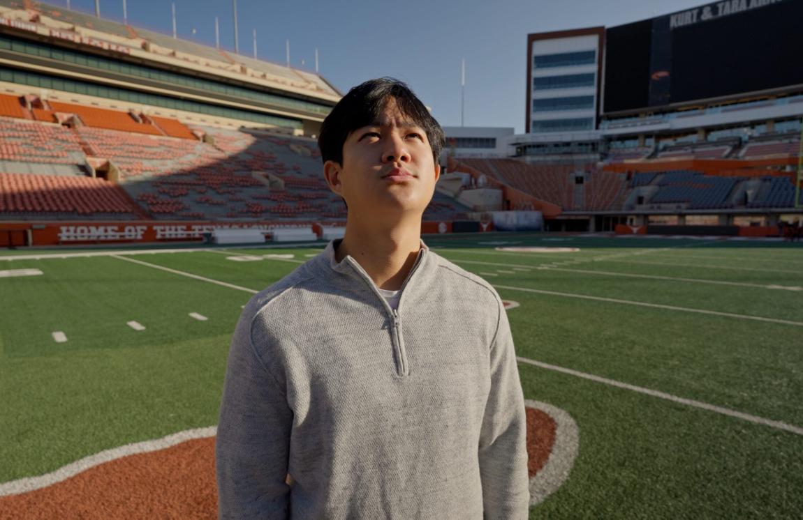 Mark Cho stands on the field at Darrell K Royal-Texas Memorial Stadium at The University of Texas at Austin.