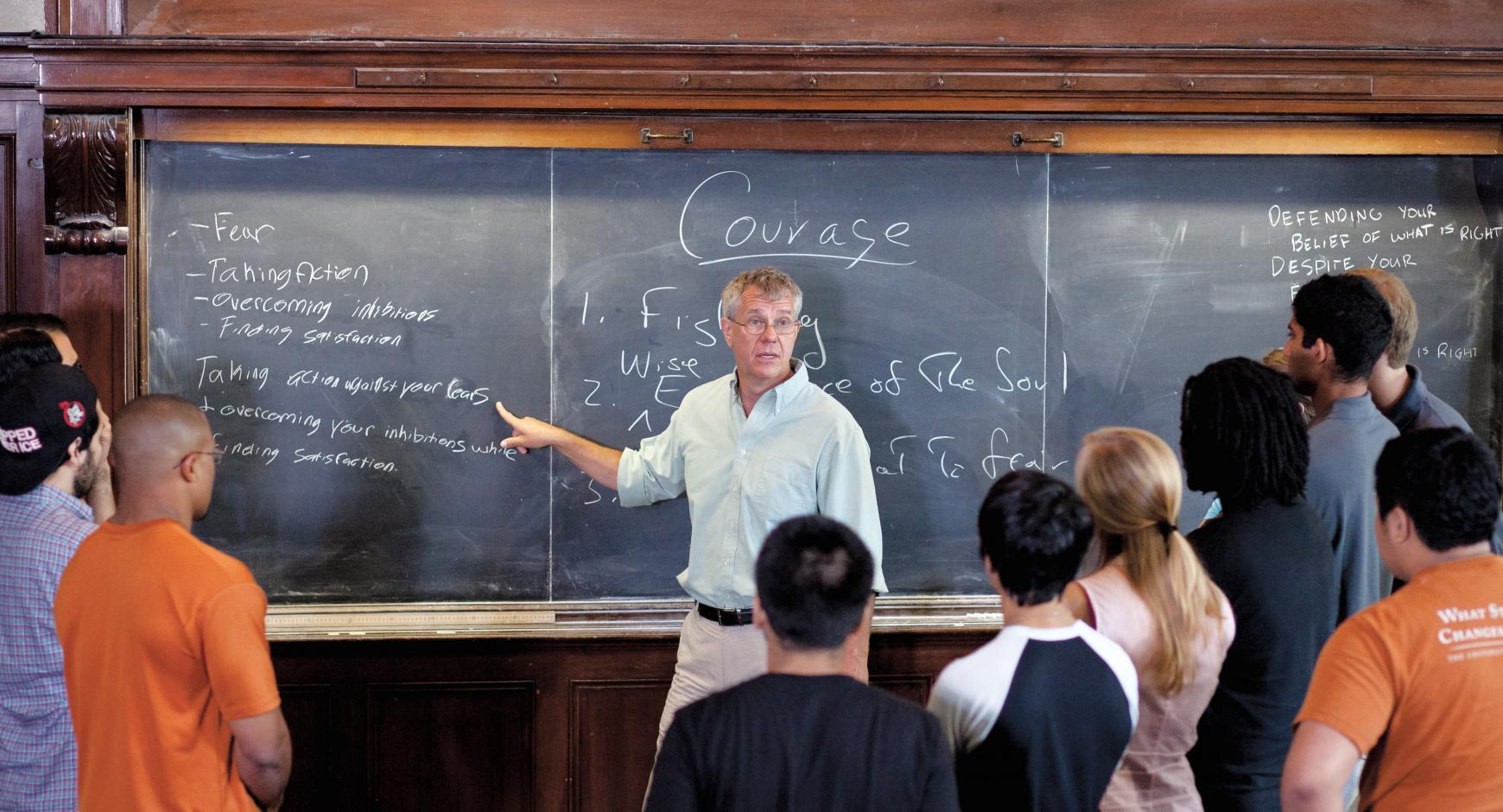Student talking with professor in front of chalkboard