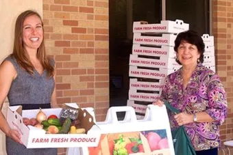faculty member picks up their farm to work produce box