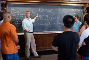 Teacher at chalk board teaching