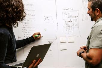 two people working together at a whiteboard
