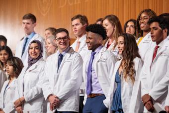 Students pose for a group photo at a Dell Medical School white coat ceremony.