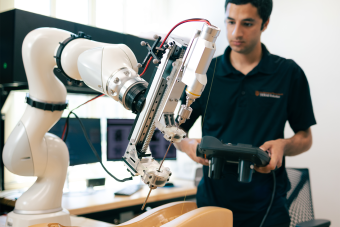 A researcher controls a robotic arm.