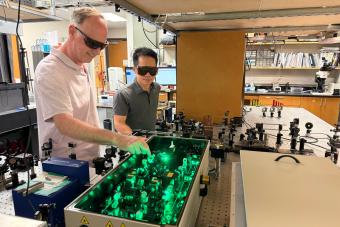 A pair of researchers wearing goggles work in their lab.