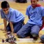 Two elemntary age students work on a robot