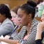 Close up of several students working in a School of law classroom. They focus intently on papers in front of them.