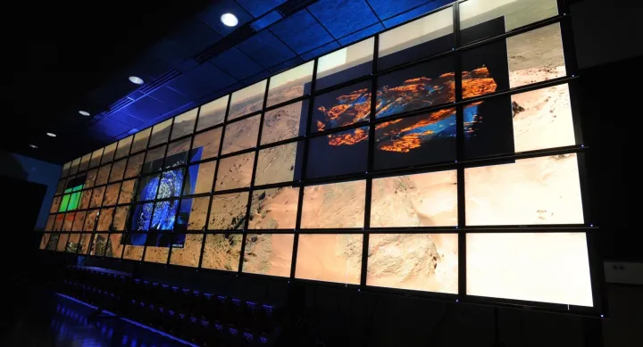 A digital wall projecting several images on a large grid.