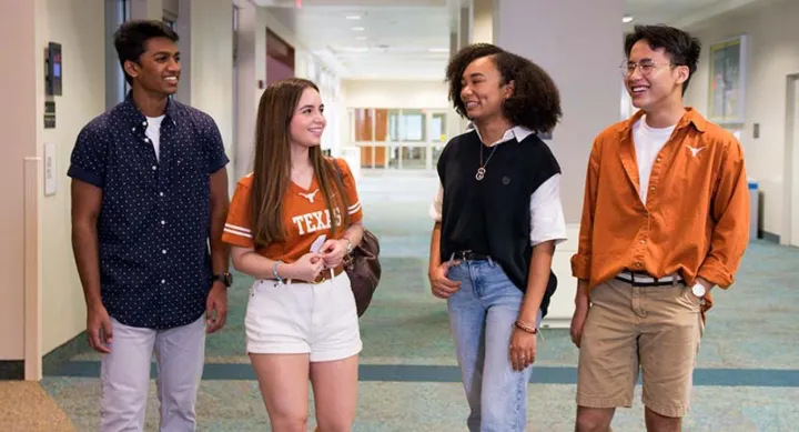 four students talking in a dorm hall