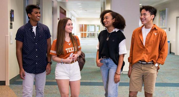 four students talking in a dorm hall